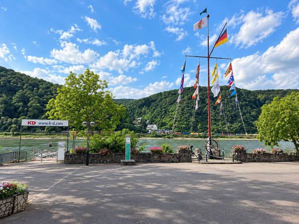 Flusspromenade mit buntem Flaggenmast
